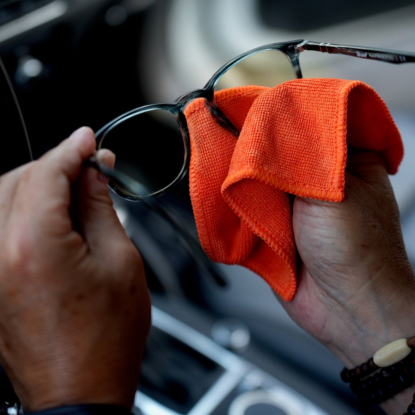 Polishing eyeglass lenses with the Whoosh microfiber cloth in a car