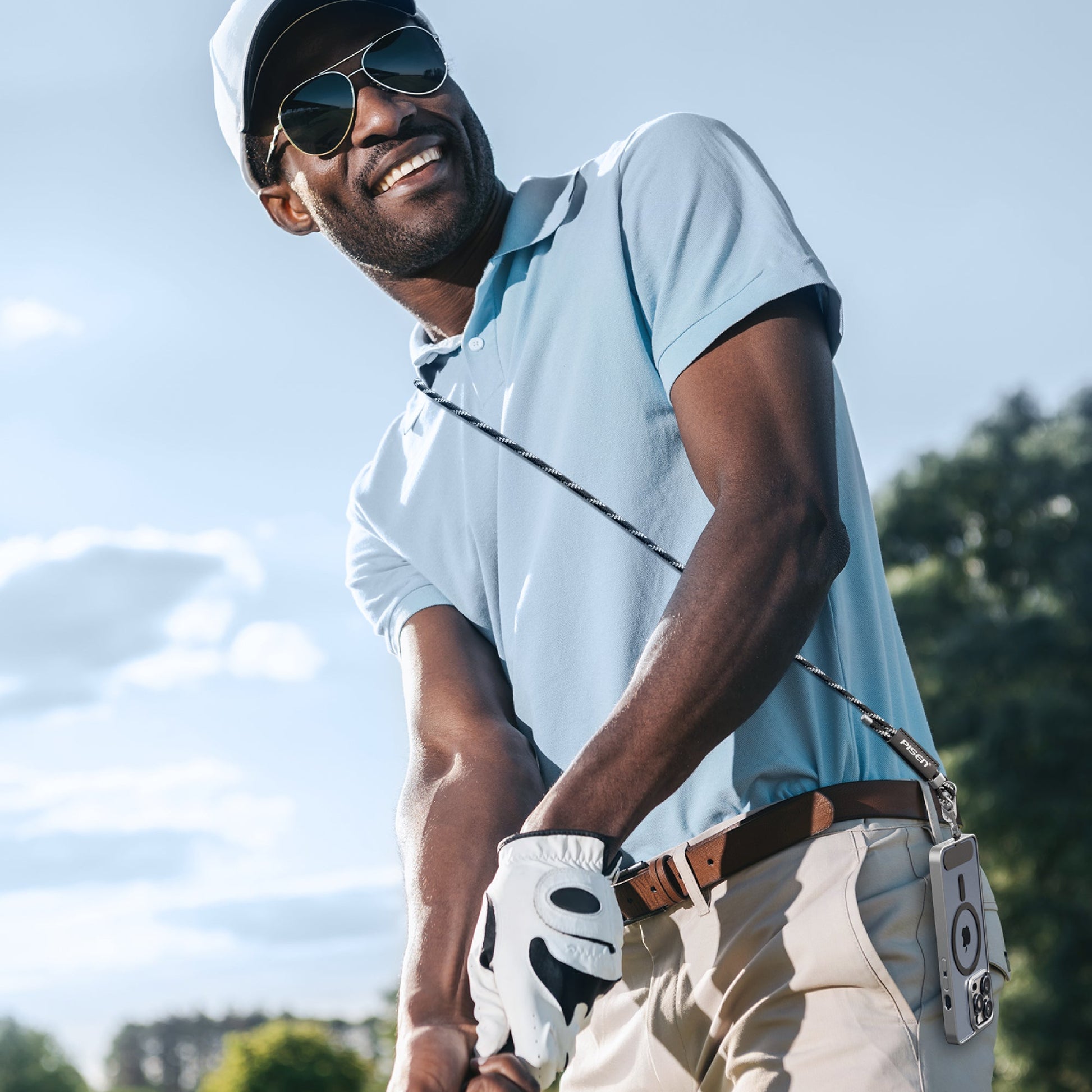 Golfer swinging with his phone secured crossbody on a PISEN braided lanyard