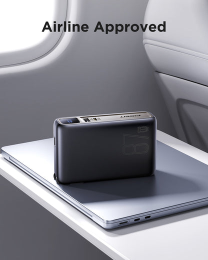Airline-approved PISEN PRO 87W power bank on a laptop atop an airplane tray table